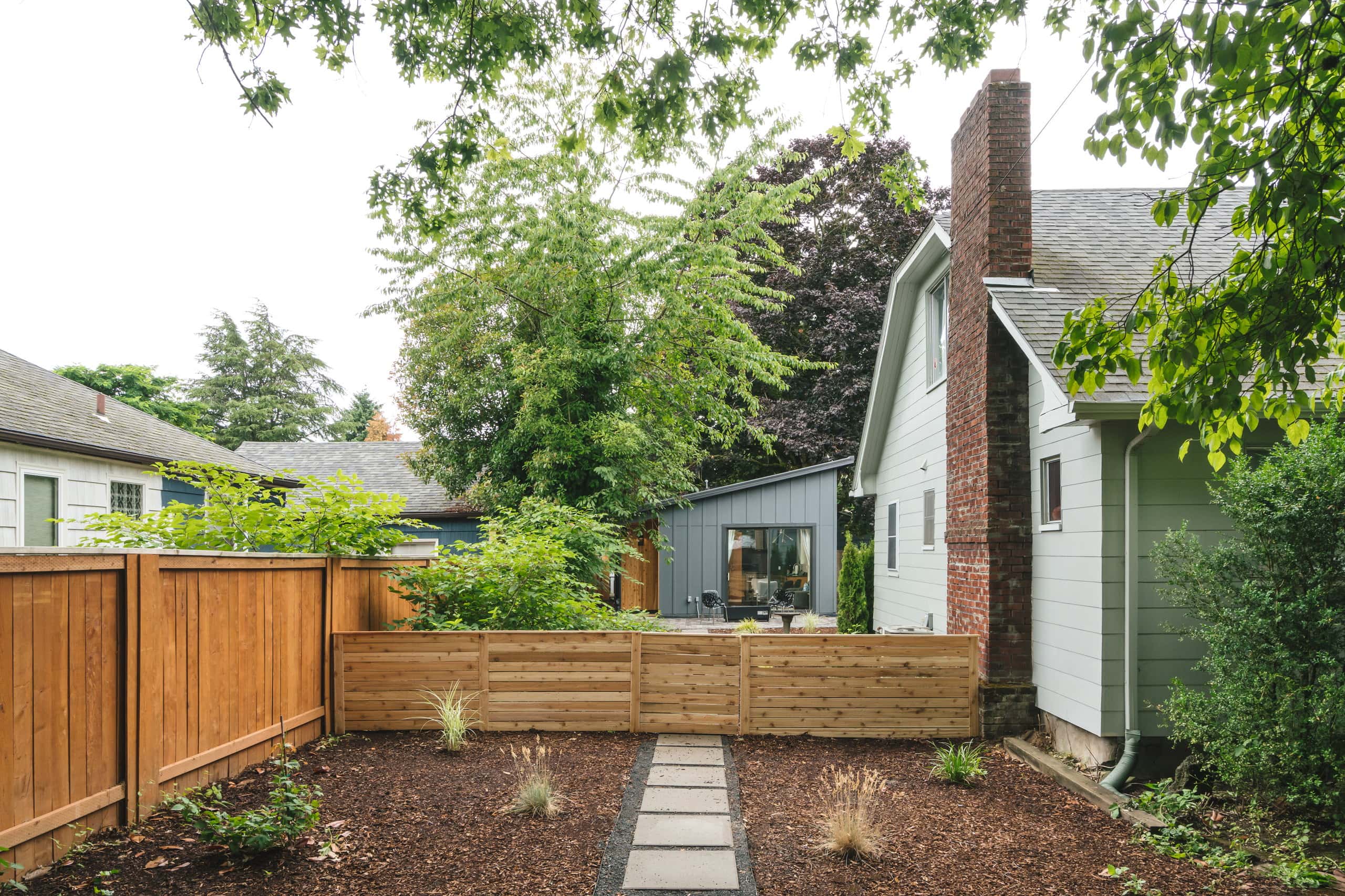 The backyard site, showing the ADU tucked behind the main house along the shared lot line.