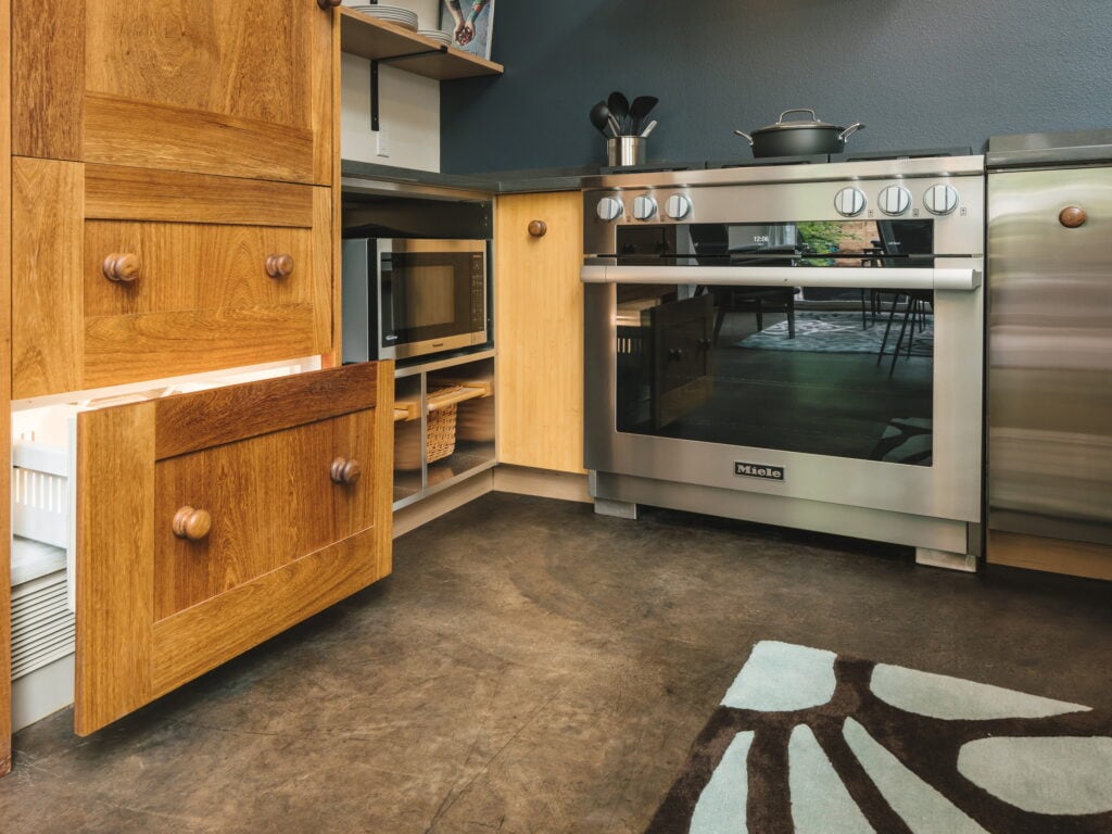 Bamboo and oak cabinetry with turned wood knobs, a pull-out drawer open beside the range.