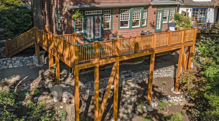 The backside of a Portland home with a new deck built over a steeply terraced backyard