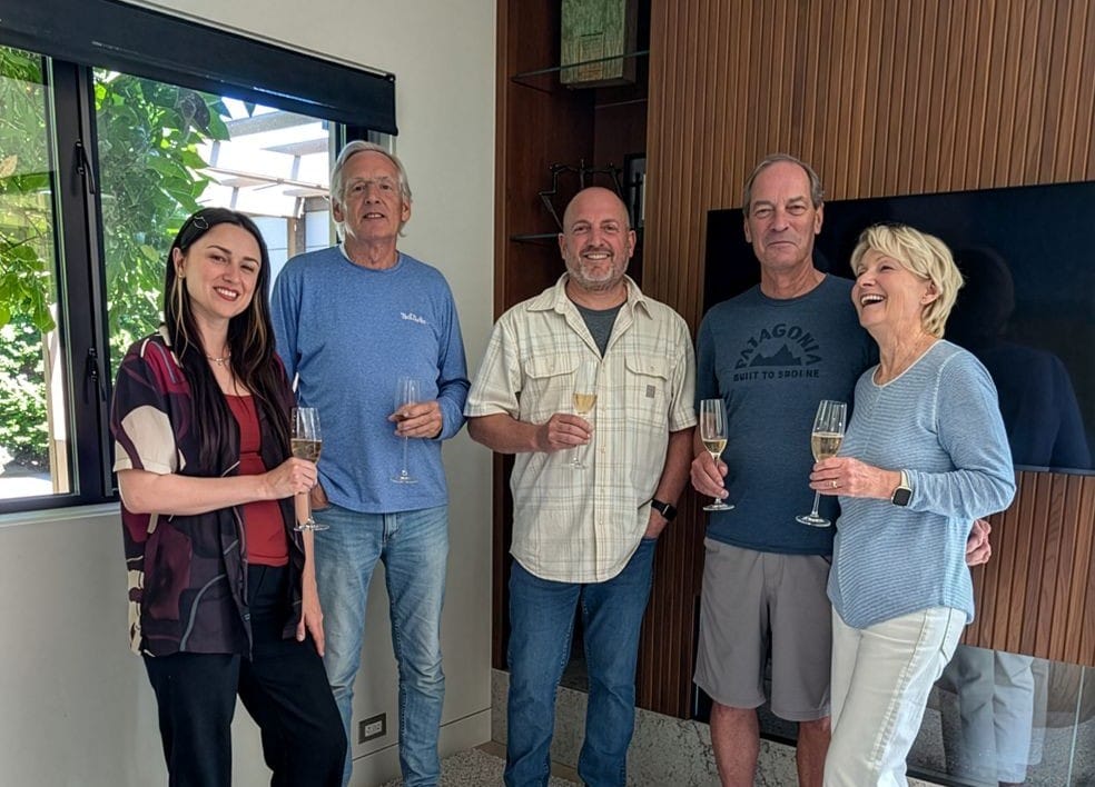 A Neil Kelly project manager, project associate, and carpenter, toasting to a remodeled living room with the homeowners