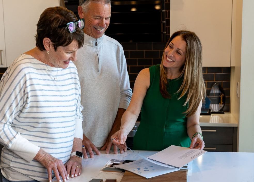 A Neil Kelly designer meets with homeowners in a kitchen to discuss design plans and materials
