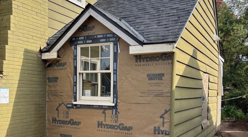A new window is installed and the home exterior is prepped for new siding with a moisture barrier