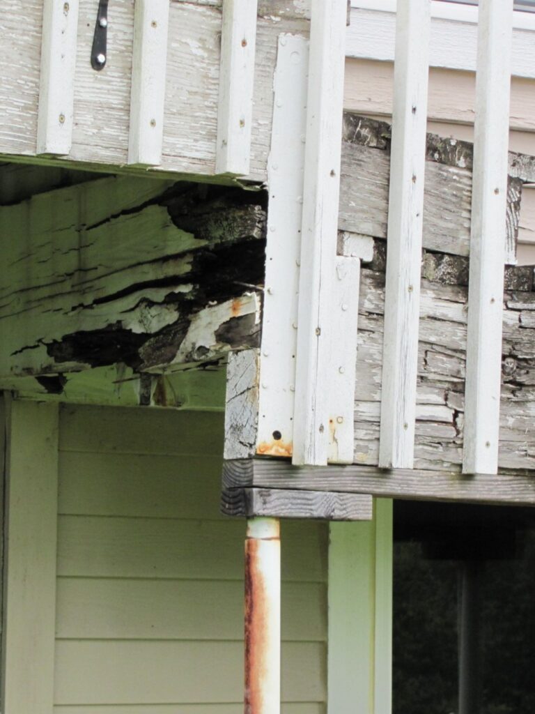 An old home exterior staircase with catastrophic moisture damage and deterioration