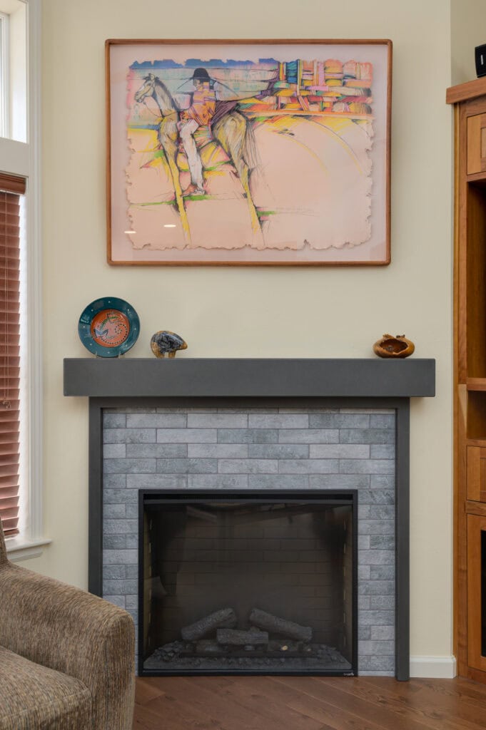 A remodeled fireplace with tile surround and cement mantel