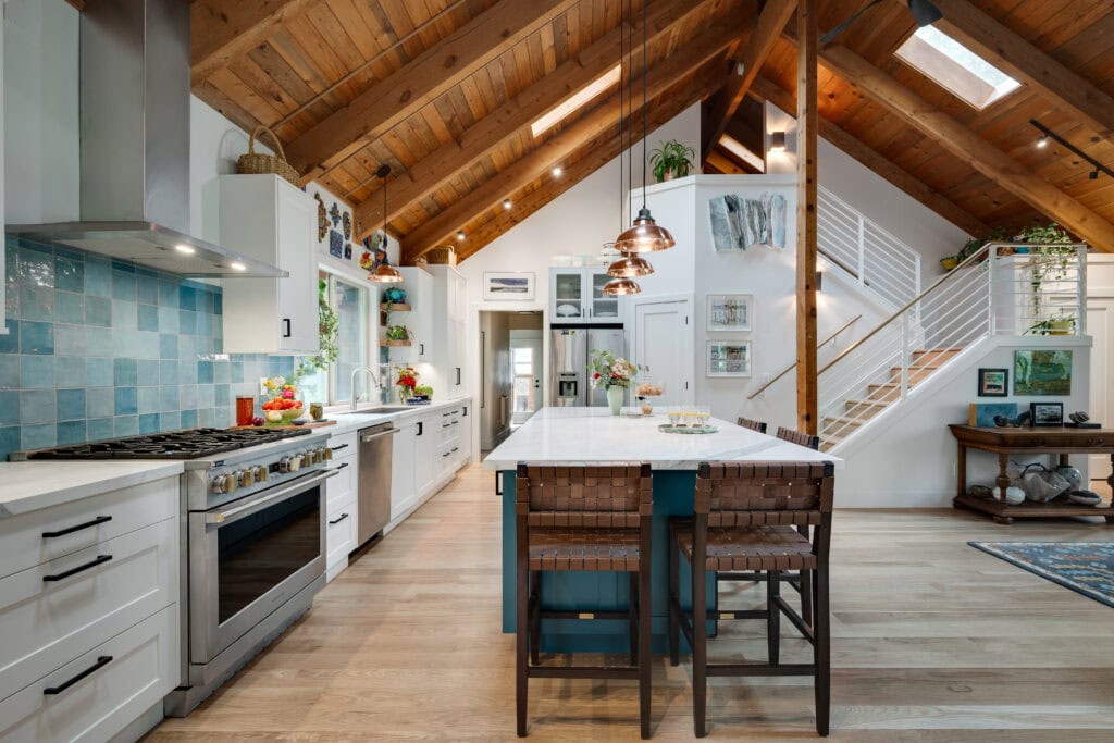 A remodeled farmhouse with vaulted ceiling, staircase, and modern kitchen