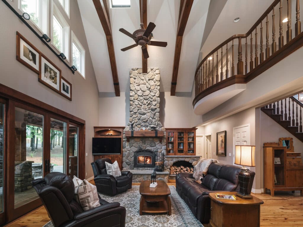 A cabin-style fireplace with river rock surround and reclaimed wood mantel