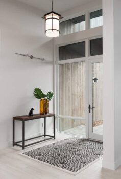 Bend Tetherow Custom Home 002 Modern custom home entryway with wood-look porcelain tile, and large windows.