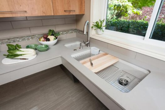Canby ADA Kitchen Portland-007 Wheelchair accessible kitchen sink with side faucet, secondary sink, tile backsplash, sink tray, and soap dispenser.