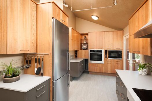 Canby ADA Kitchen Portland 012 Accessible design kitchen with wall oven, toe kick cabinets, wall microwave, track lighting, and utensil hooks.