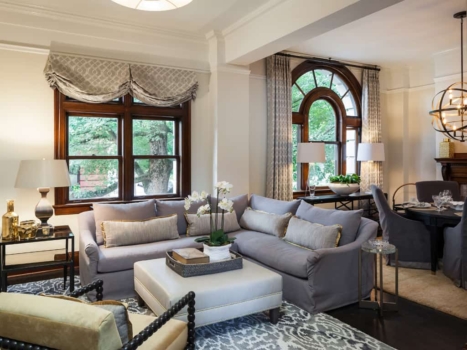 This extensive condominium remodeling project earned Byron and his team a Regional Contractor of the Year award for Historic Renovation and an Oregon Home Structure and Style award — the first such award received by Neil Kelly Company. The condo, located in a New York-style Renaissance building originally constructed in 1913, contained historic features that needed to be protected, such as mahogany stairs, doors, railing, and trim. Remodeled condo historic design living room with window treatments, curtains, L-shaped couch, hardwood floors, and chandelier