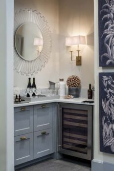 Davis Street Condo Portland 005 Condo remodel built in corner bar with wine refrigerator, cabinet storage, wall sconce, and circular mirror.