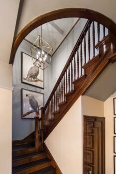 Davis Street Condo Staircase Portland 001 Condo remodel with historic wood staircase with dark finish, baulusters, powder blue colored wall, and chandelier.