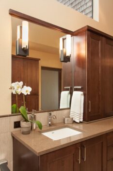 Mt Park Bathroom Portland 010 Bathroom vanity with undermount sink, under sink and wall cabinet storage, quartz countertops, large mirror, and wall lights.