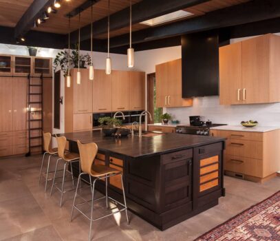 Vashon Island kitchen Seattle Japanese influenced kitchen with large island counter with seating, concealed range hood, double sink, and slab cabinets.