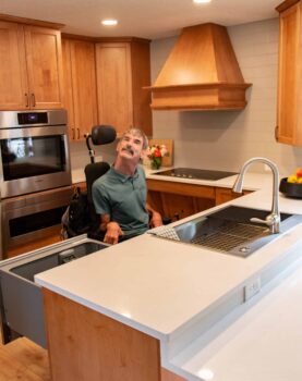 A wheelchair-bound homeowner in his kitchen remodeled by Neil Kelly Company