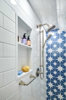 Bright white shower with blue star accent tile.