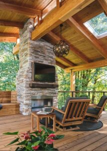 Oversized beams and exposed raw wood rafters creating tiered roof over outdoor kitchen