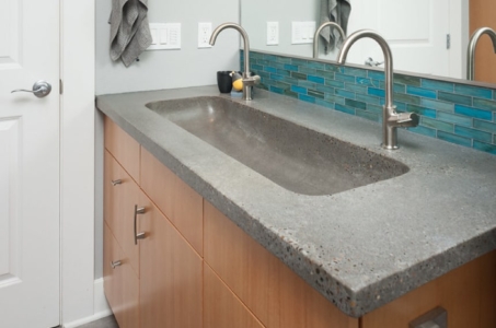 Grey, quartz countertop, double faucet vanity with smooth, wooden drawers.
