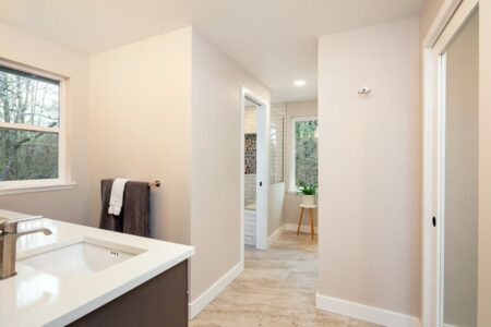 The remodeled primary bath is an open and inviting space with lots of natural light flowing in through the windows.