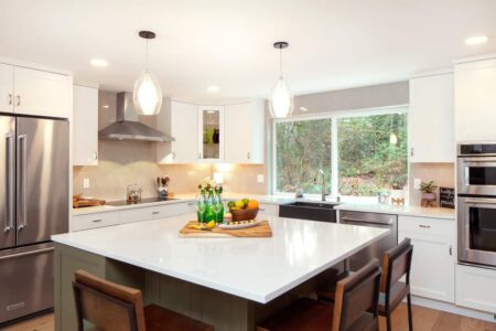 Remodeled kitchen features pendant lights over an expansive new island.