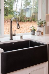 A detail of the of the kitchen faucet and under counter sink.