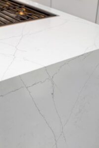 Quartz slabs create a seamless "waterfall" edge on each side of the island.