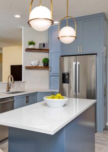 Center kitchen island with a white countertop beneath two hanging lights.