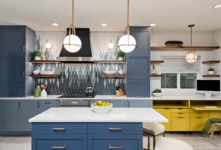 Modern kitchen with blue wooden cabinets, a center island, white countertops, and stainless steel appliances.