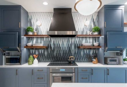 Electric cooktop with a stainless steel hood in the middle of a countertop.