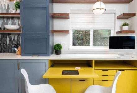 Yellow pull-out kitchen table with two white chairs
