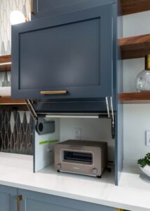 Kitchen appliance garage with a toaster oven inside and a light blue wooden door.