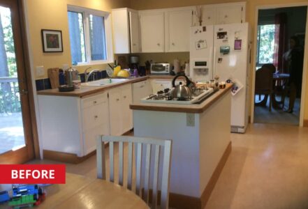 Cooking island in the middle of a kitchen with white cabinetry.