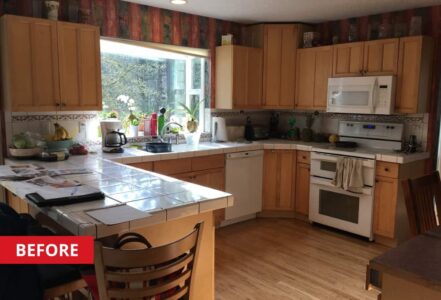 U-shaped kitchen with light woodwork panels and white tile countertops.