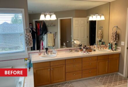 Dual-sink vanity against a mirror with two wall sconces.