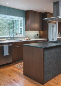 Modern kitchen with an under-mount stainless steel sink and a center island with a gas stove and ceiling fan.