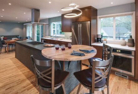 Modern kitchen with a center island, hightop table, and stainless steel appliances.