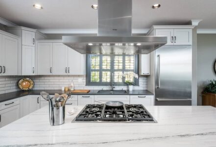 Wooden cutting board on top of quartz countertops with flat eased edge detail.