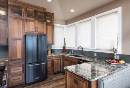 Kitchen with granite countertops and walnut cabinets with a unique modern door style.