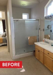 Shower with a sliding glass door to the left of a double vanity.