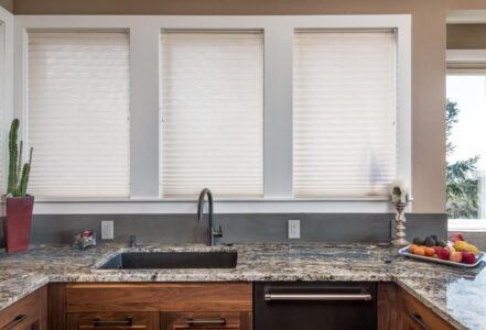 Granite countertop around an undermount sink with a metallic finish.