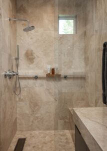 Enlarged curbless shower with a chrome shower head and handle.