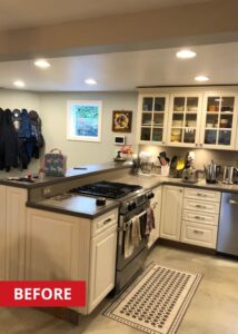 Gas stove in a kitchen with grey countertops and white cabinets.
