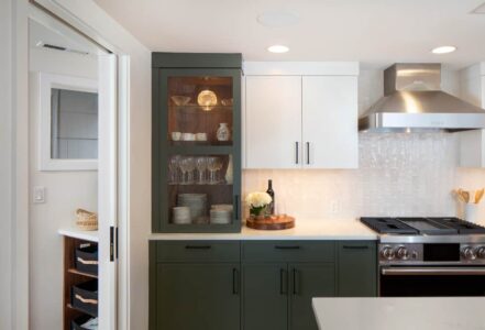 Gas kitchen stove with a hood vent above to the right of a counter.