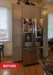 Stainless steel refrigerator/freezer built into grey cabinets.