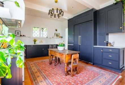 Standing island in the middle of a vintage kitchen with two stools on opposite ends.