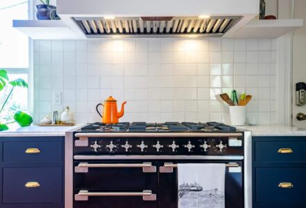 Large vintage-inspired Aga range with an orange tea kettle on top.