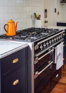 Large vintage-inspired Aga range with an orange tea kettle on top.