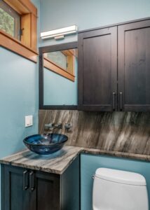 Blue bowl-shaped sink in a small bathroom.