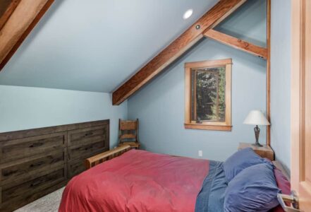 Bed with dark blue and red bedding.