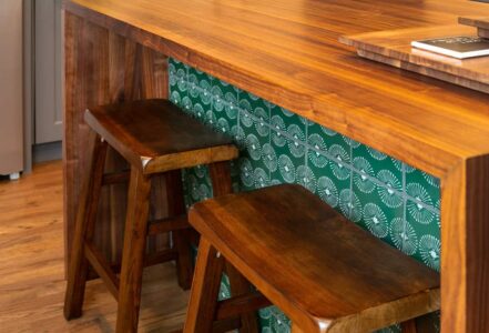 Two wooden kitchen stools underneath a wooden kitchen island.